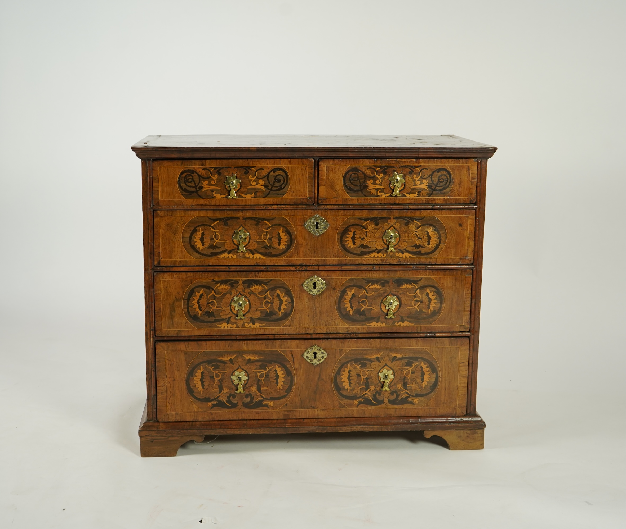 A William and Mary walnut and floral marquetry chest on later bracket feet
